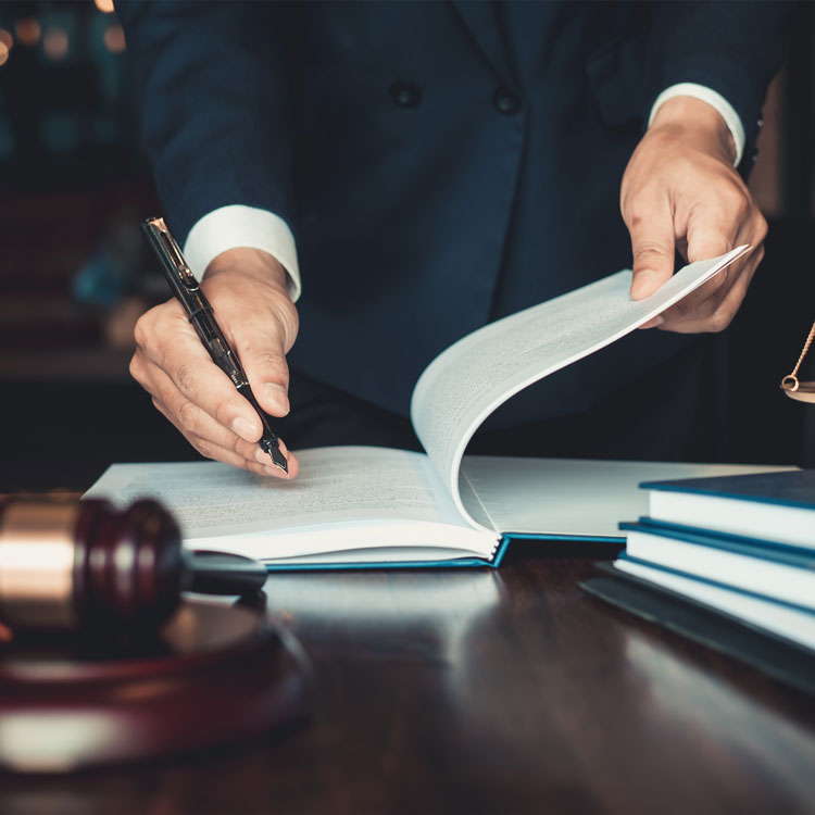 Lawyer signing documents beside a judge's gavel