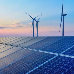Wind turbines and solar panels at sunset