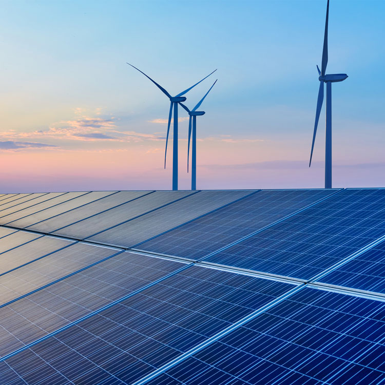 Wind turbines and solar panels at sunset